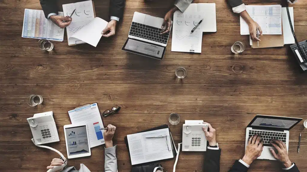 Meeting of members of a company that shows computer screens and notes